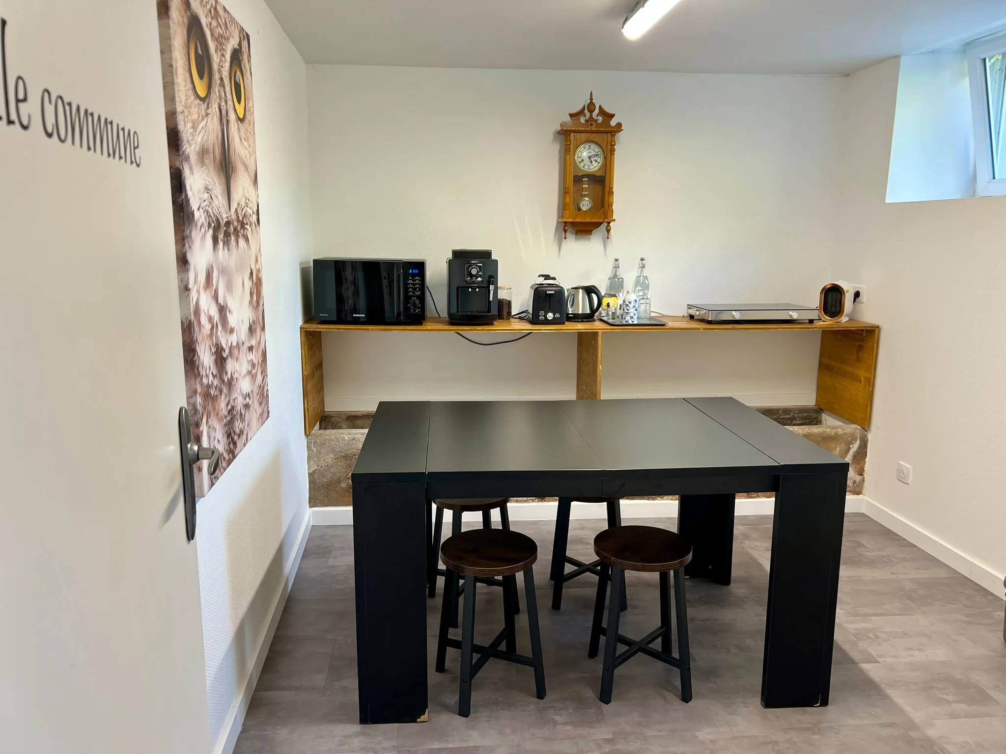 Salle commune intérieure de La Grange d'Hélène avec table et coin cuisine équipé